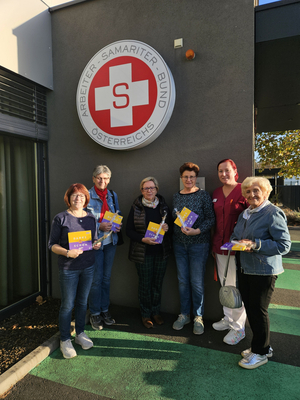 Sechs Personen stehen vor dem Gebäude des Arbeiter-Samariter-Bundes mit Informationsmaterial.