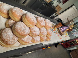 Eine Reihe von zuckergestreuten Berliner Brot auf einem Tisch.