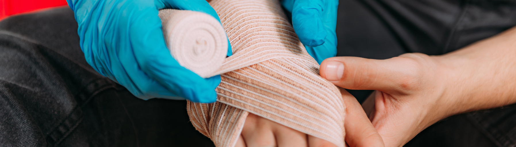 Ein Verband wird um eine verletzte Hand gewickelt.