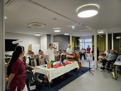 Eine festliche Veranstaltung mit Musikern und Gästen in einem gemütlichen Raum.