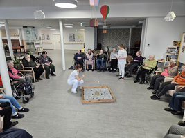Gruppenspiel mit älteren Menschen in einem Gemeinschaftsraum.