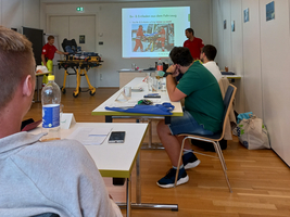 Ein Präsentationsraum mit Personen, die Informationen über das Laden und Entladen geben.