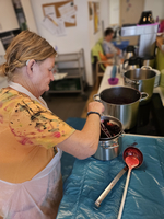 Eine Frau rührt Obst in einem Topf in einer Küche.