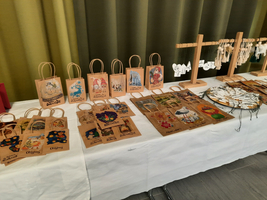 Bunte Geschenktüten mit weihnachtlichen Motiven auf einem Tisch ausgestellt.