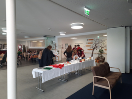 Ein Tisch mit herbstlichen Dekorationen und Personen, die zusammenarbeiten.