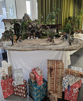 Weihnachtliche Krippe mit Figuren und Geschenken darunter.