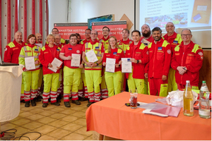 Gruppe von Rettungskräften in uniform mit Urkunden bei einer Zeremonie.