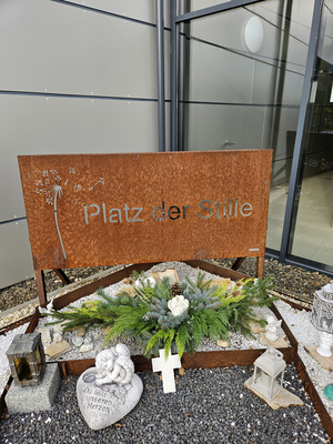 Platz der Stille mit Pflanzen und Erinnerungssteinen.