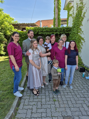 Gruppe von Menschen im Freien, einige tragen Arbeitskleidung, andere feine Kleidung.