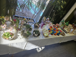 Tisch mit frühlingshaften Blumenarrangements und dekorativen Objekten.