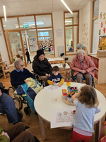 Kinder und Senioren sitzen gemeinsam am Tisch und malen.