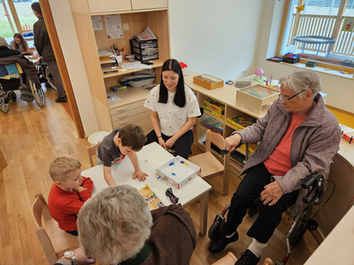 Kinder und Senioren spielen gemeinsam in einem gemütlichen Raum.