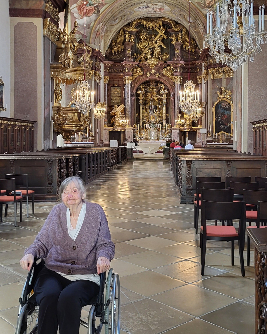 Eine Frau im Rollstuhl in einer prächtigen Kirche.