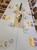 Ein gedeckter Tisch mit Getränken und Geschirr für eine Besprechung.