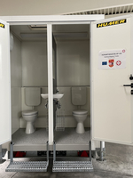 Hygienewagen mit zwei Toiletten und einem Waschbecken.
