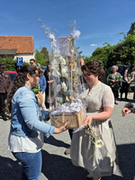 Zwei Frauen tauschen Geschenke bei einer Feier im Freien.