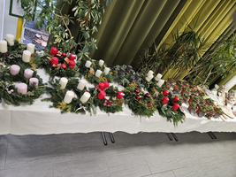 Tisch mit Adventskränzen, Kerzen und festlichen Leckereien.