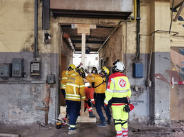 Rettungskräfte arbeiten gemeinsam an einer stabilen Stütze in einem Gebäude.