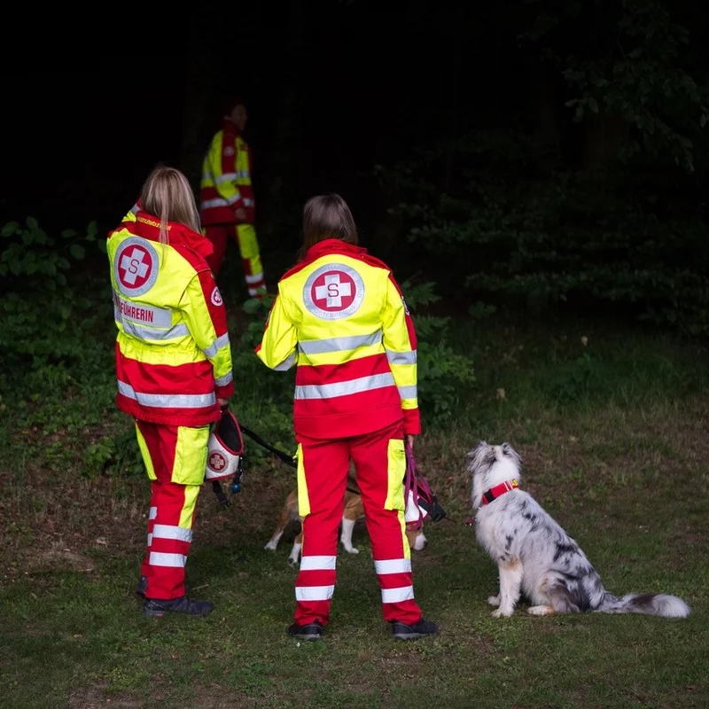 Zwei Rettungshundeführerinnen und ein Rettungshund bei einer Übung